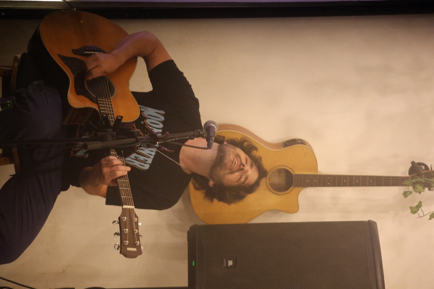 Stevie Matthews singing and playing acoustic guitar during a live set at Baliwood, Bali